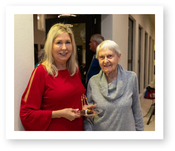 Staff Member and Elderly Resident Sharing Dessert at Assisted Living